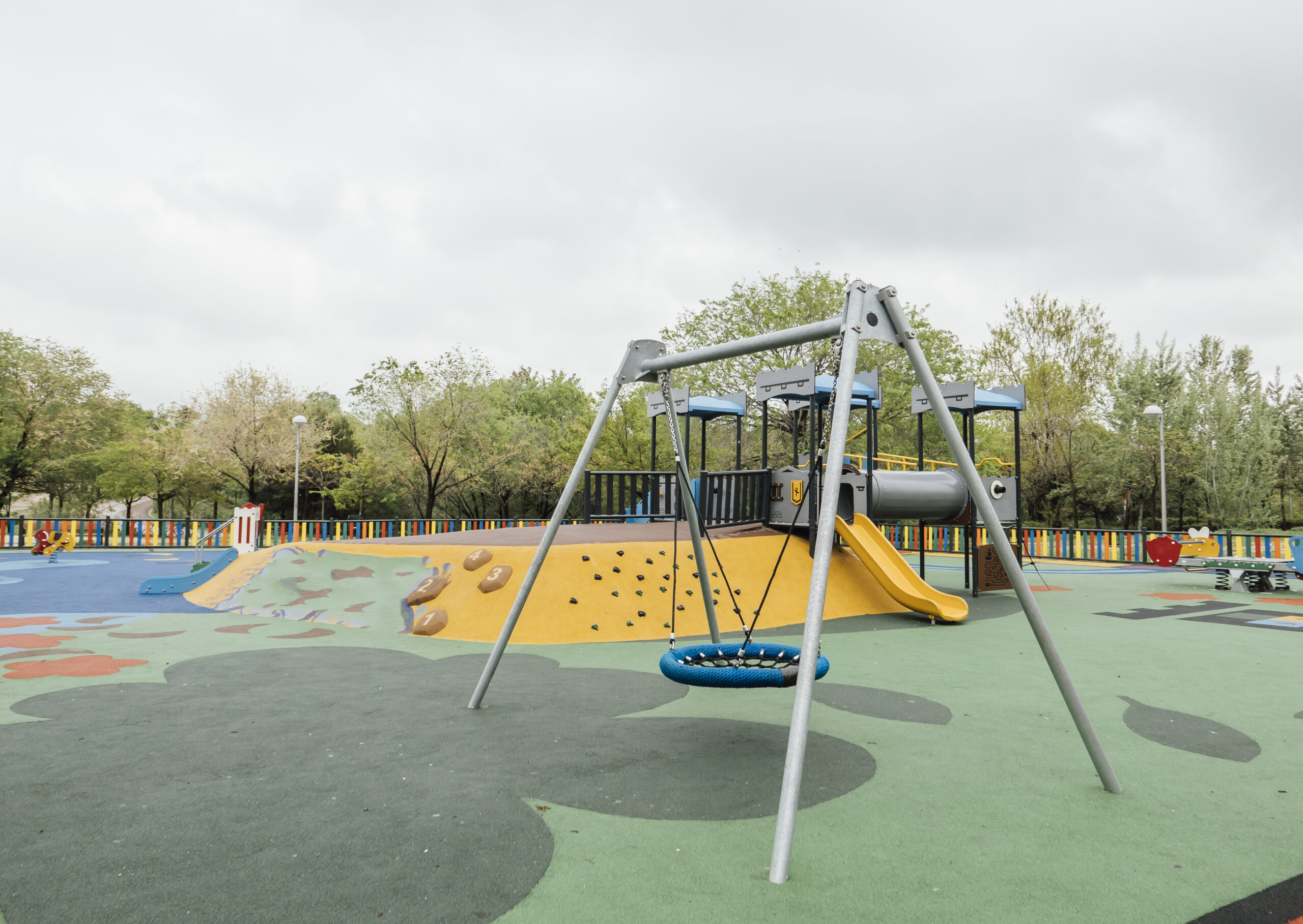 Bērnu spēļu laukums ar šūpolēm, slidkalniņiem un kāpelēšanas paaugstinājumiem